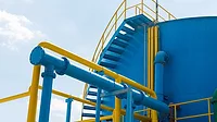 Blue storage tank with yellow and blue pipes