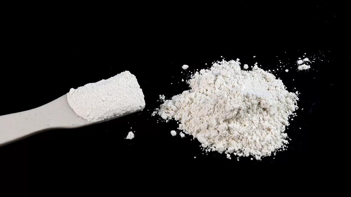 Alt text: Pile of White Chemical Powder on black table