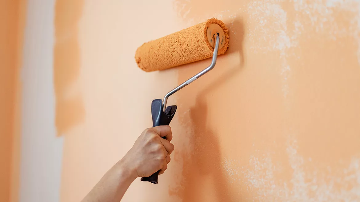 GI-2073106686-1170x658.jpg Hand of woman painting a wall orange with paint roller