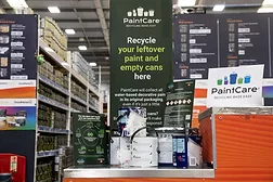hotograph of a PaintCare recycling station inside a hardware store, designed for collecting leftover paint and empty cans.