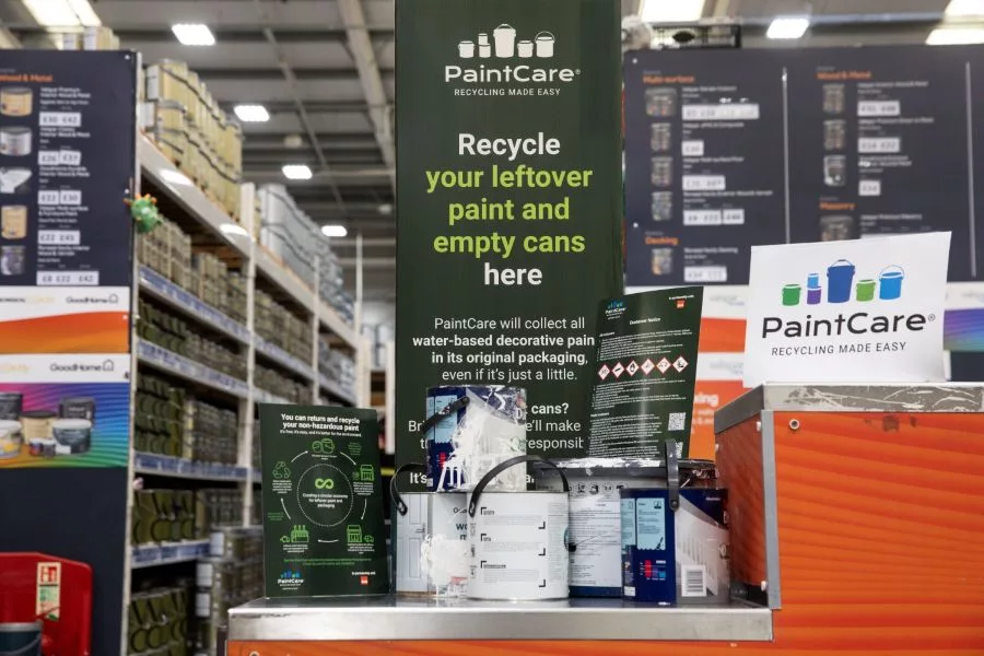 hotograph of a PaintCare recycling station inside a hardware store, designed for collecting leftover paint and empty cans.