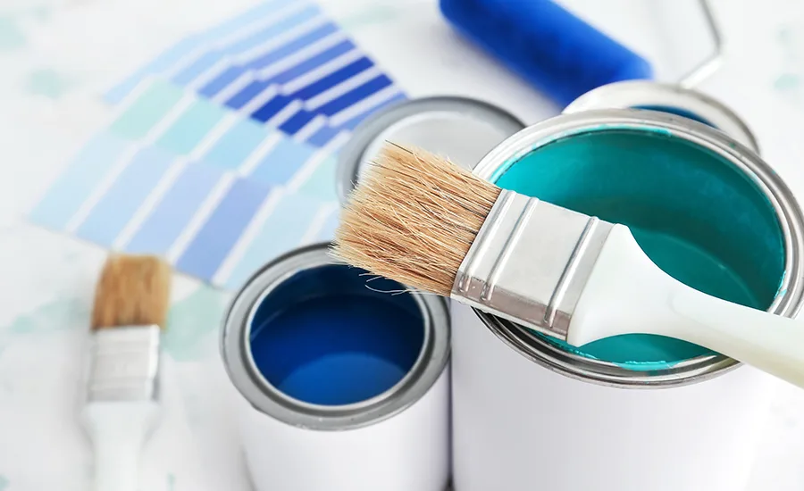 Paint cans, paintbrushes, and color swatches for coating selection.