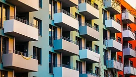 Alt text: Colorful apartment building with block formed balcony 