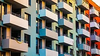 GI-921273992-1170x658.jpg Alt text: Colorful apartment building with block formed balcony