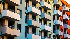 Alt text: Colorful apartment building with block formed balcony 