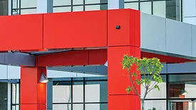 Details of gray and red facade on modern residential building made of aluminum panels.