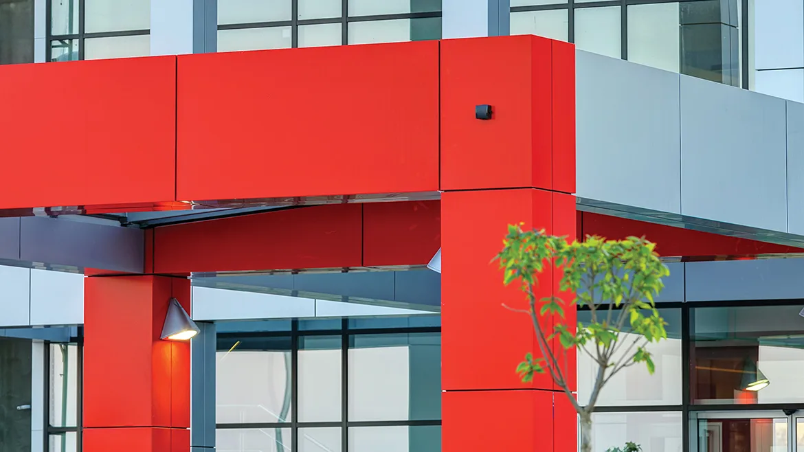 Details of gray and red facade on modern residential building made of aluminum panels.