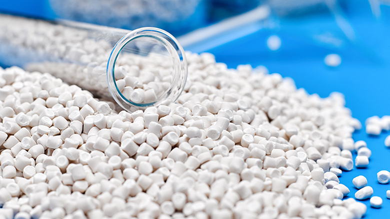 closeup of a white polymer granules with a chemical flask