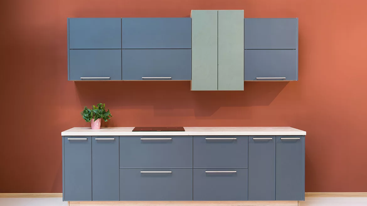 Modern kitchen with rust-colored walls and slate-colored cabinets