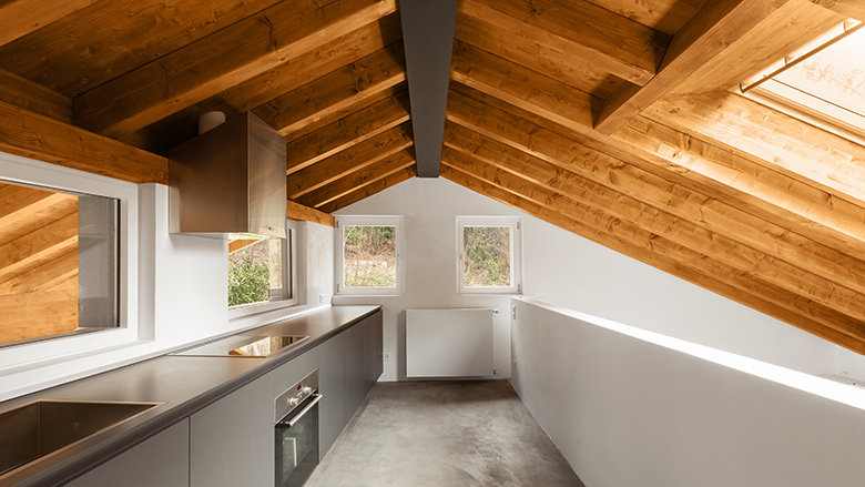 modern house interior featuring wooden beams in ceiling and grey resin flooring