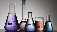 five laboratory flasks on a white backlight