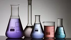 five laboratory flasks on a white backlight