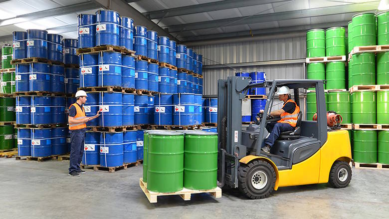 Group of workers in a warehouse with chemicals and a forklift