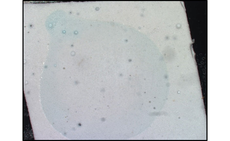 Optical image showing a color change for a coating after exposure to a drop of water.