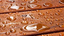 A close up on a recently sealed cottage deck just after the summer rain.