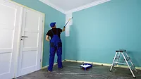 GI-1015387276-1170x658.jpg Man, working overalls, painting the wall in white