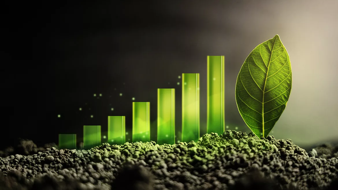 Sustainable business concept showing a green bar graph of growth on dark soil and a green leaf as the goal