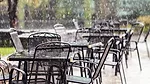 Rain falling on restaurant tables