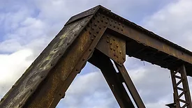 The upper corner of the rusty old bridge