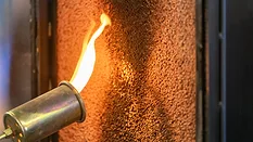 Close up of a flame torch testing flame retardant material, demonstrating fire resistance and safety in industrial applications