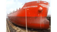 Photo of the hull of a large, red ship