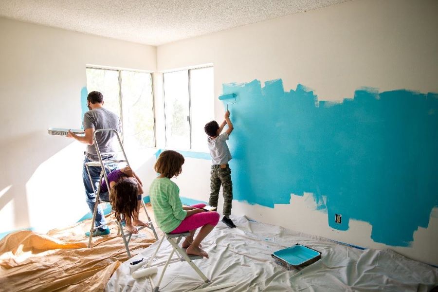 a group of people painting a room